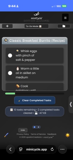miniCycle in dark mode showing dark gray backgrounds with white text and lighter gray task cards. A notification shows 2 completed tasks cleared. The sun icon in the lower right corner indicates dark mode is active.